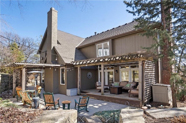 rear view of property with outdoor lounge area, roof with shingles, a pergola, a chimney, and a patio area