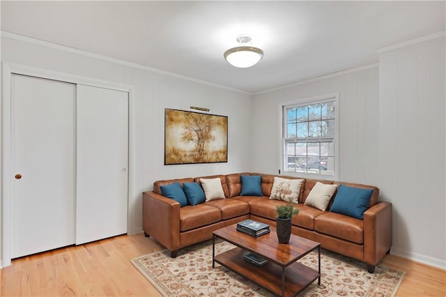 living area featuring crown molding and light wood-style flooring