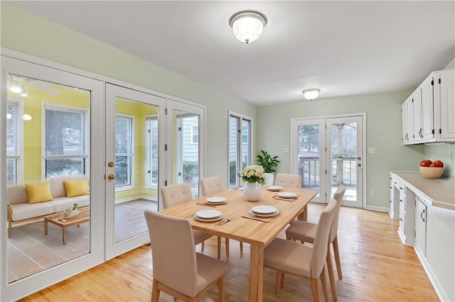 dining room with french doors, light wood-type flooring, and baseboards