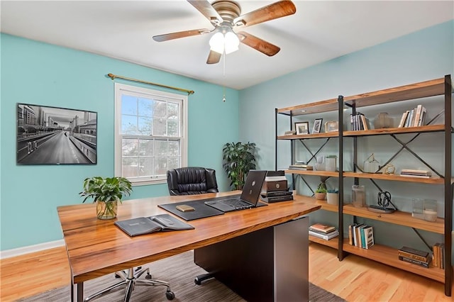 home office featuring baseboards, ceiling fan, and wood finished floors