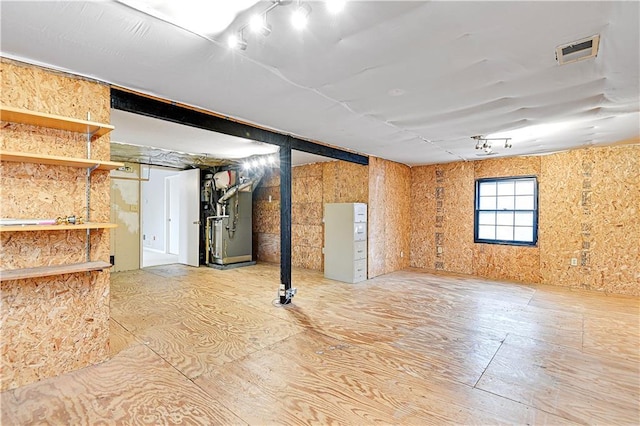 basement featuring visible vents and heating unit