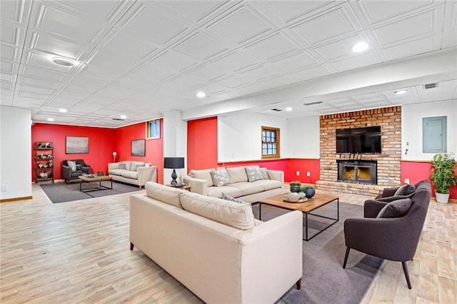 living area featuring light wood finished floors, visible vents, baseboards, electric panel, and recessed lighting