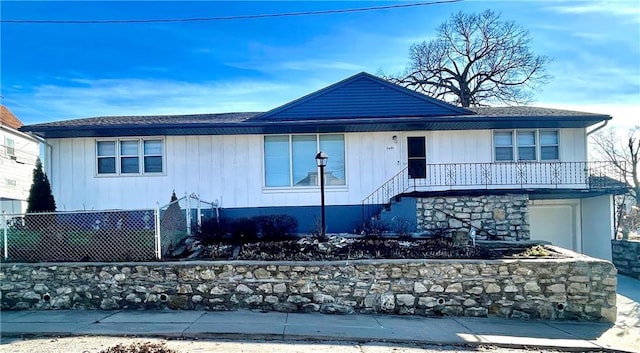 view of front of property with fence, an attached garage, and stairs