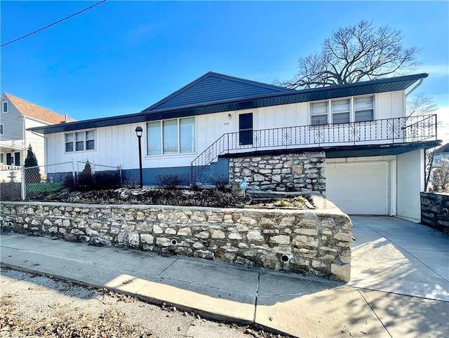 view of front of home featuring a garage, driveway, and fence