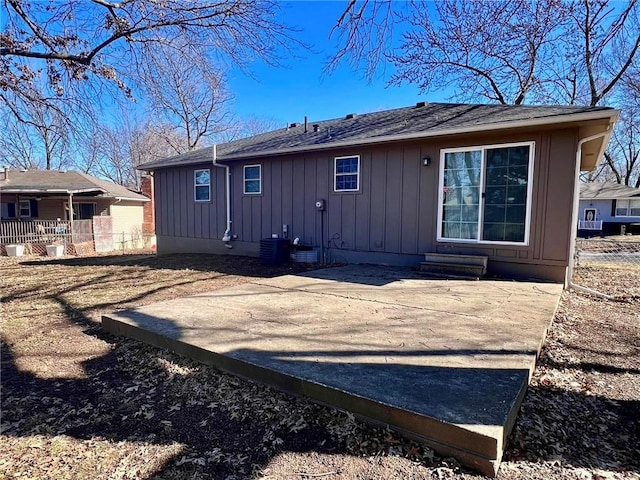 back of house featuring entry steps, cooling unit, and board and batten siding