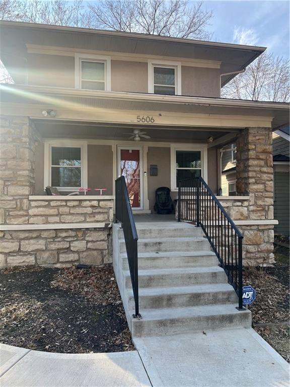 view of exterior entry featuring stone siding and a porch