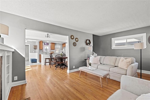 living room featuring light wood-type flooring and a textured ceiling