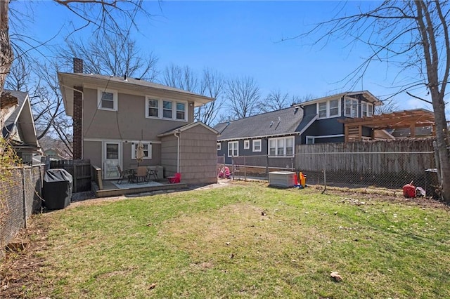 back of house with a wooden deck, a chimney, a fenced backyard, a yard, and a pergola