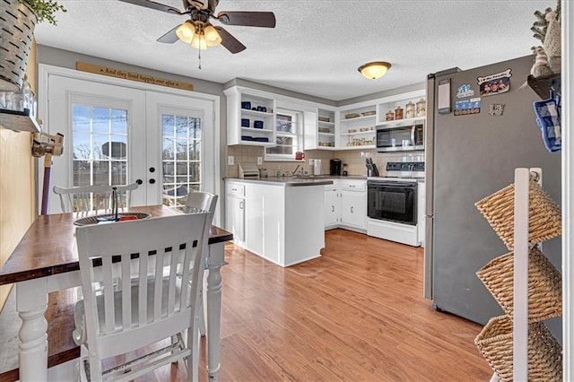 kitchen featuring stainless steel appliances, french doors, light wood-type flooring, decorative backsplash, and open shelves