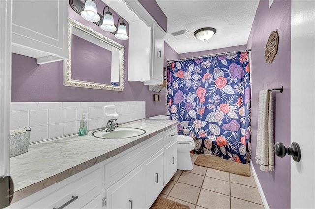 bathroom featuring a textured ceiling, toilet, tile patterned floors, vanity, and decorative backsplash