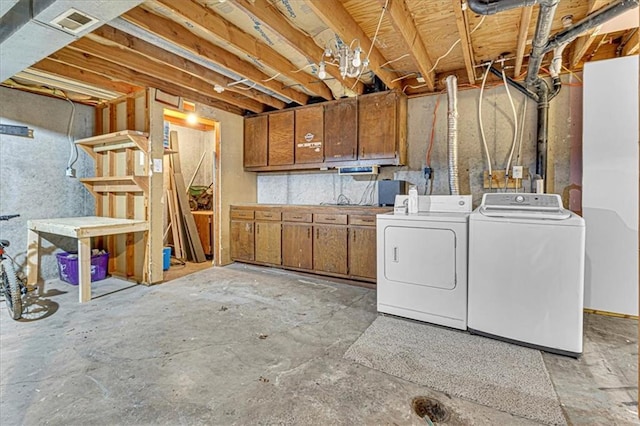 washroom featuring laundry area, visible vents, and separate washer and dryer