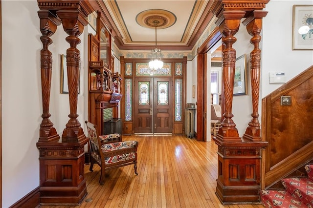 entryway with stairs, light wood-style flooring, and crown molding