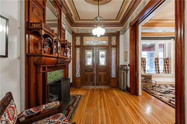 entrance foyer with light wood-style floors and ornamental molding