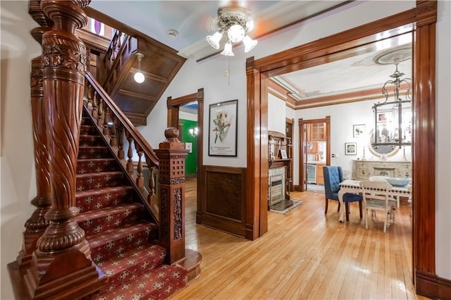 staircase with ornamental molding and hardwood / wood-style floors