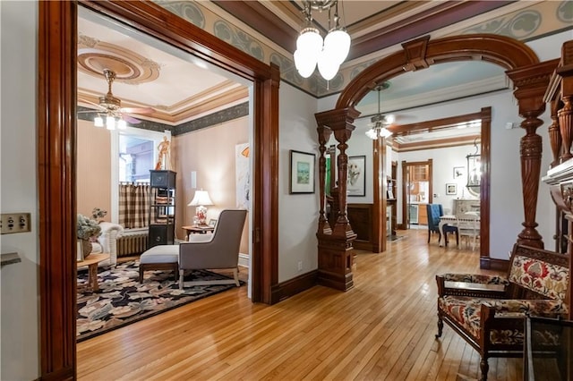 interior space with arched walkways, ornate columns, wood-type flooring, and crown molding