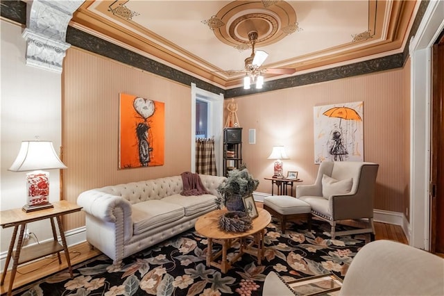 living area with baseboards, crown molding, and wood finished floors