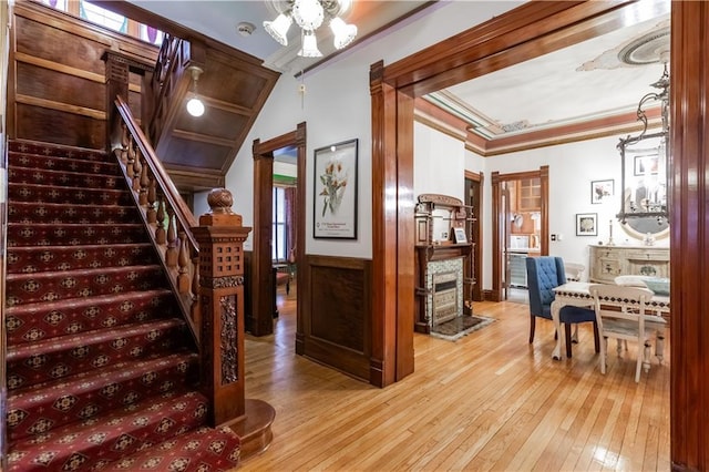 stairway featuring hardwood / wood-style flooring, crown molding, and wainscoting