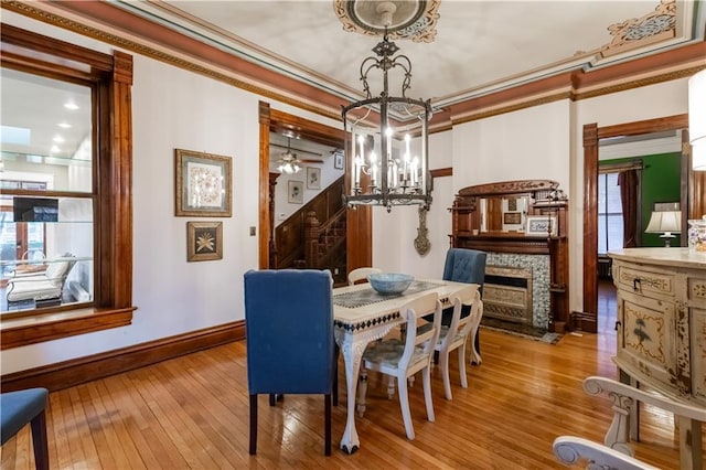 dining area with stairway, a chandelier, hardwood / wood-style floors, and ornamental molding