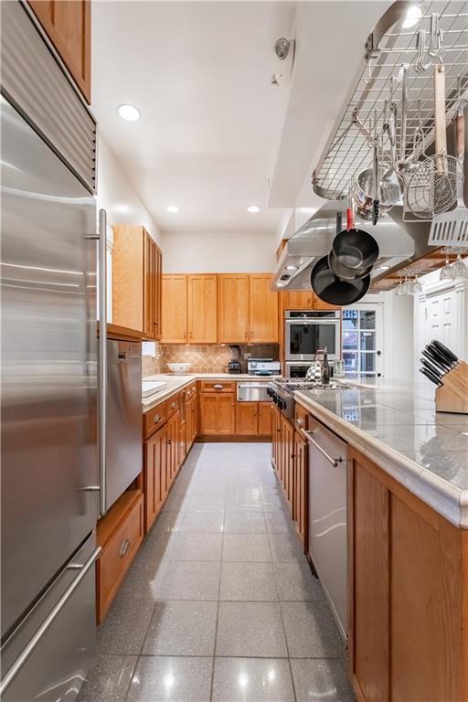 kitchen with tasteful backsplash, recessed lighting, stainless steel appliances, light countertops, and light tile patterned flooring