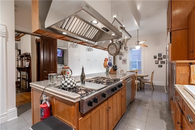 kitchen with brown cabinetry, a center island, stainless steel gas cooktop, and extractor fan