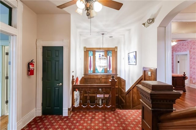 foyer entrance featuring baseboards, arched walkways, ceiling fan, and wood finished floors