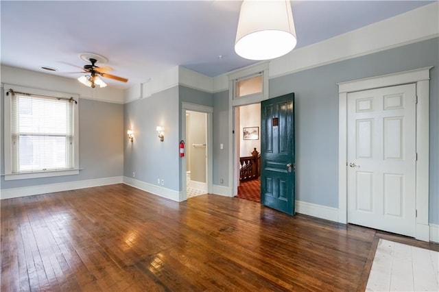 spare room featuring ceiling fan, hardwood / wood-style flooring, and baseboards