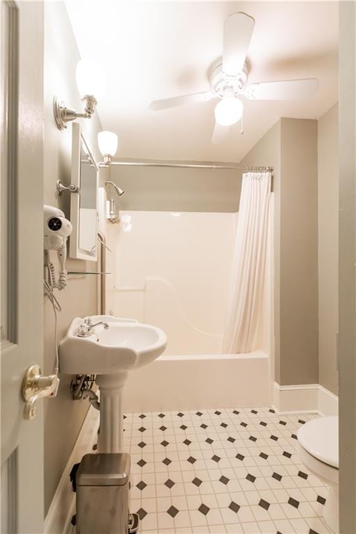 bathroom with ceiling fan, shower / bath combo, and toilet