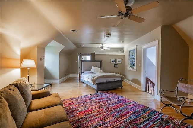 bedroom featuring light wood finished floors, baseboards, visible vents, and a ceiling fan