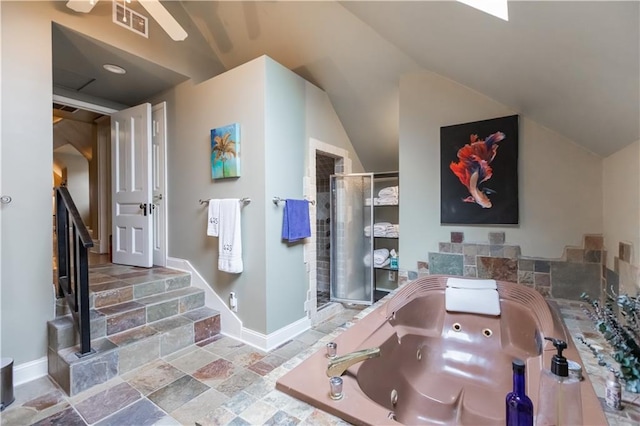 full bathroom with stone tile floors, baseboards, vaulted ceiling, a shower stall, and a whirlpool tub