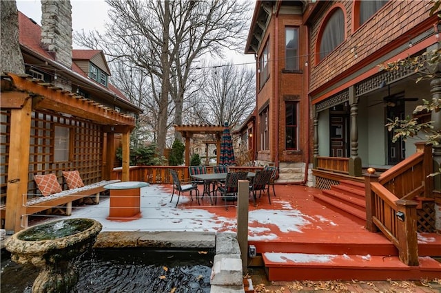 wooden terrace with outdoor dining area and a pergola