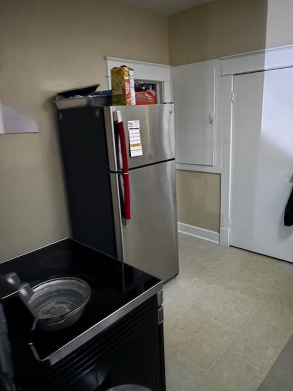 kitchen featuring light floors and freestanding refrigerator