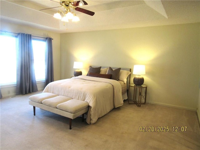 bedroom featuring light colored carpet, ceiling fan, and baseboards