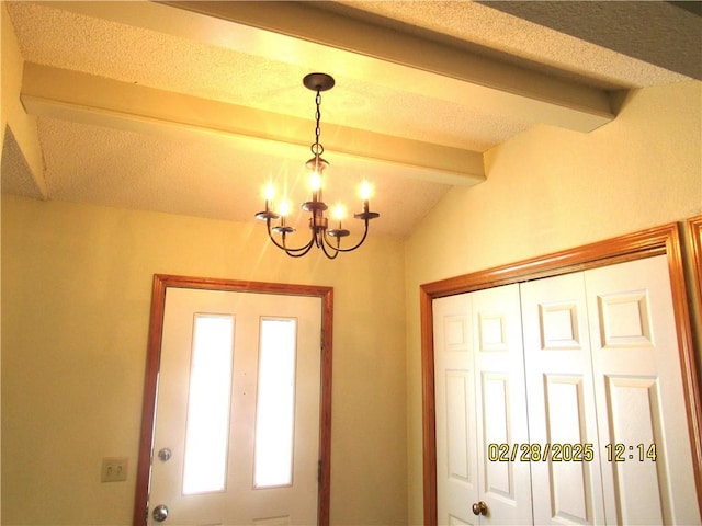 entrance foyer with vaulted ceiling with beams, a notable chandelier, and a textured ceiling