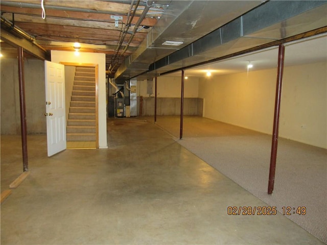 finished basement with heating unit and stairway