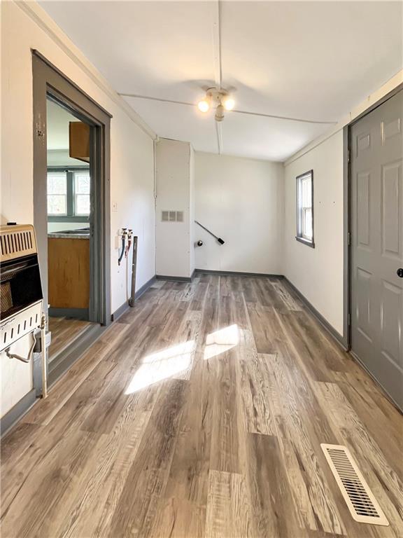 interior space featuring heating unit, visible vents, and wood finished floors