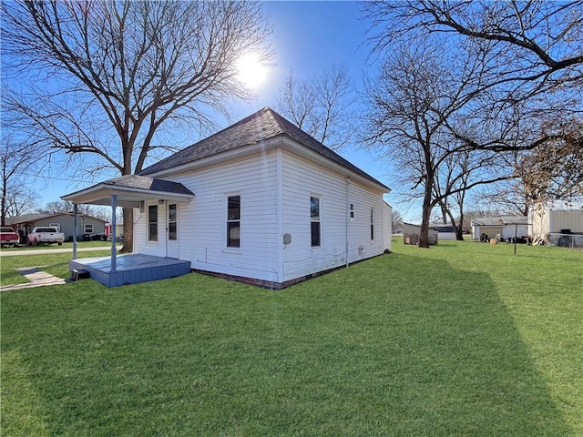 view of home's exterior featuring a shingled roof and a yard