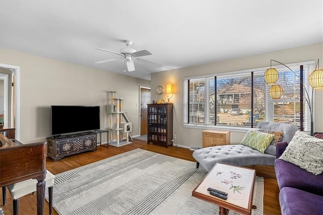 living room featuring wood finished floors, ceiling fan, and baseboards