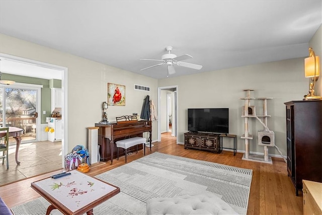living room featuring visible vents, ceiling fan, wood finished floors, and baseboards