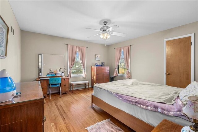 bedroom featuring visible vents, ceiling fan, light wood-style flooring, and multiple windows