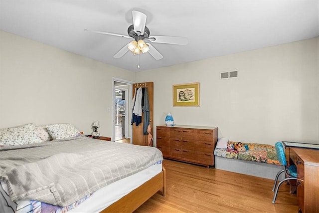 bedroom with visible vents, a ceiling fan, and light wood finished floors