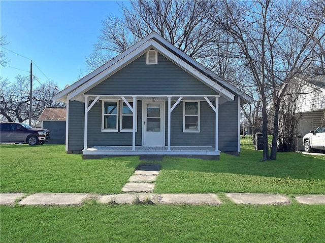 bungalow-style home with covered porch and a front lawn