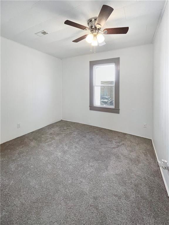 spare room featuring attic access, visible vents, ceiling fan, and carpet flooring