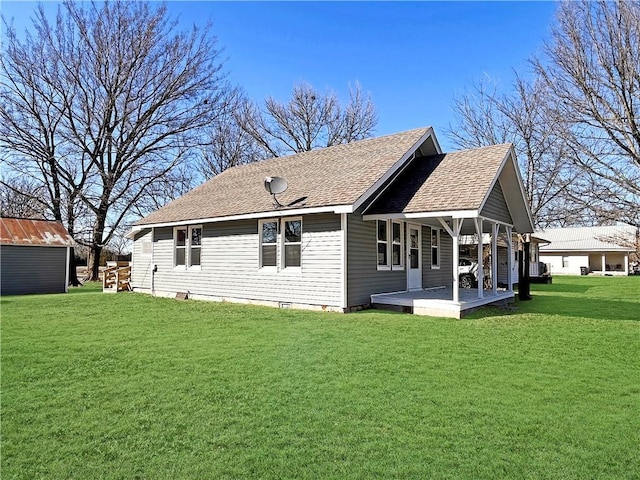 rear view of house featuring a storage shed, roof with shingles, an outdoor structure, and a lawn