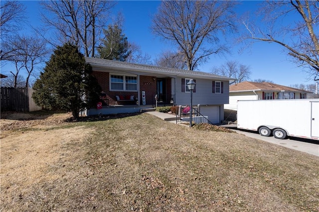 ranch-style house featuring brick siding, fence, a porch, a front yard, and a garage