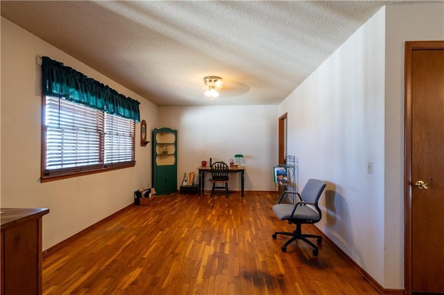 office area with a textured ceiling and wood finished floors