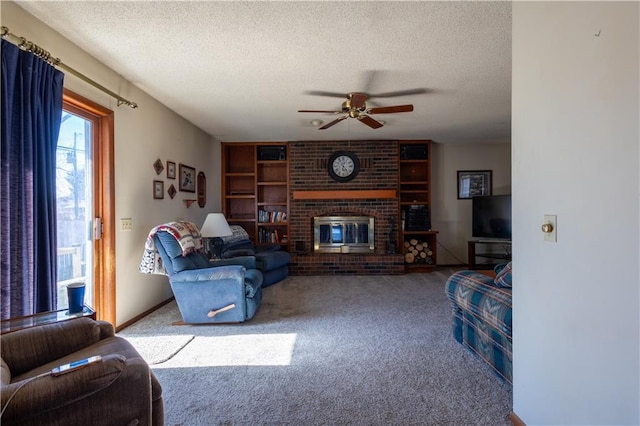 carpeted living area featuring a textured ceiling, a fireplace, and a ceiling fan