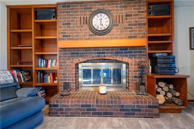 living area featuring a brick fireplace, built in shelves, and carpet