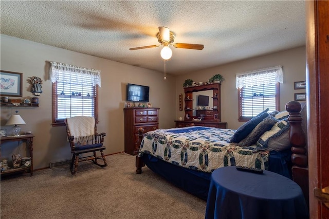 carpeted bedroom featuring a textured ceiling and ceiling fan