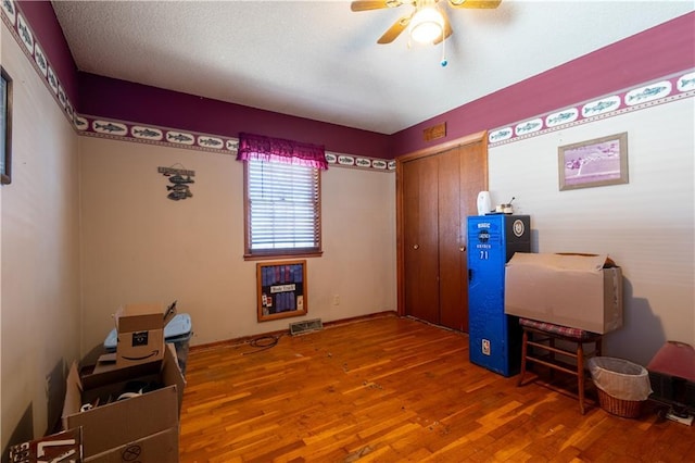 office space with visible vents, ceiling fan, and wood finished floors