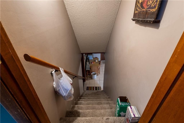 stairway featuring a textured ceiling